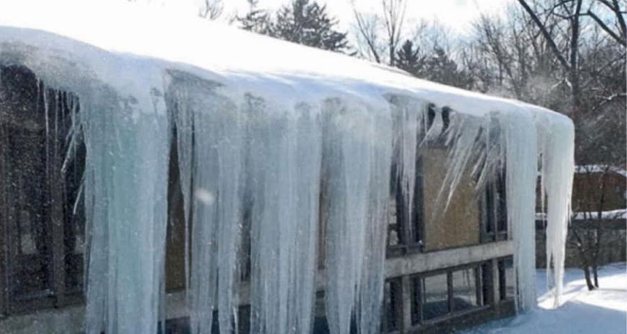 密歇根州大急流城屋顶上的大型冰柱的冰坝移除